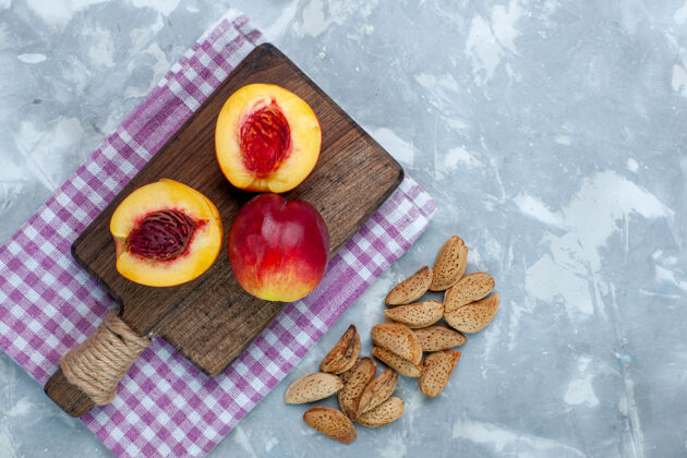 盘子在浅白的桌子上俯瞰新鲜的桃子 醇香可口的水果和坚果醇香生的桃