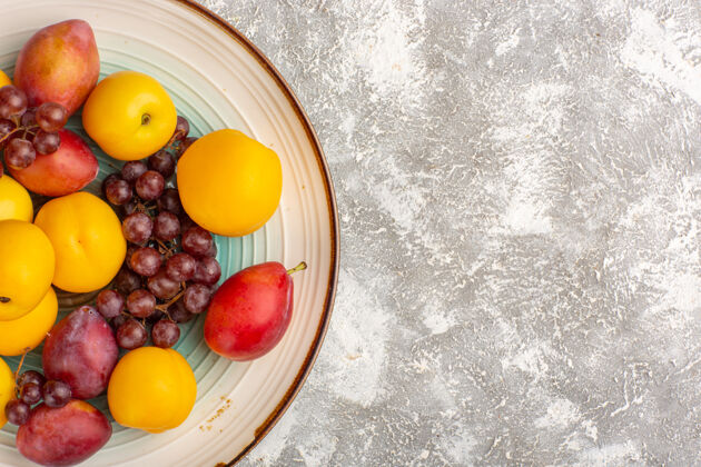 醇香顶视图新鲜甜杏与红葡萄和李子内板上的白色表面健康饮食顶部