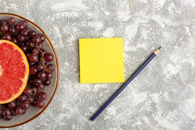 新鲜顶视图新鲜葡萄柚戒指与红葡萄和贴纸上的白色表面葡萄钢笔热带