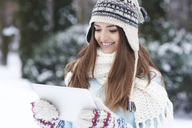 温暖带着户外装置的年轻女子下雪帽子冬天
