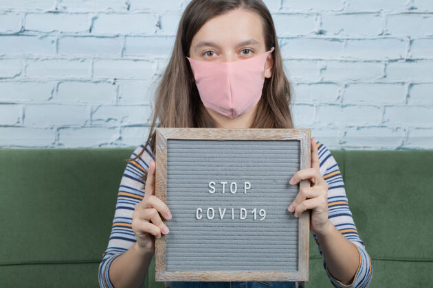 从业者拿着反对科维德和潘多米的海报的年轻女孩绝育抗议治疗