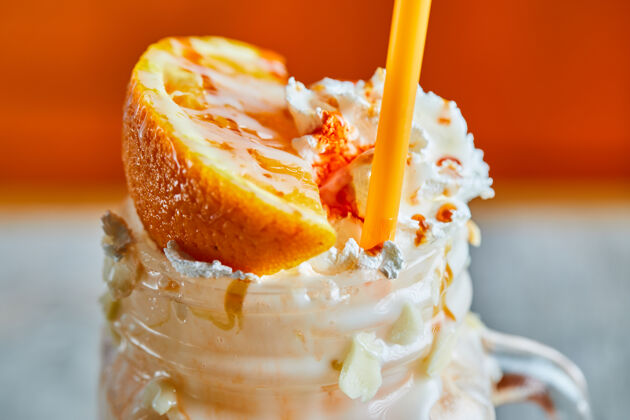 饮料在明亮的表面撒上橘子冰沙和稻草大的奶昔新鲜的