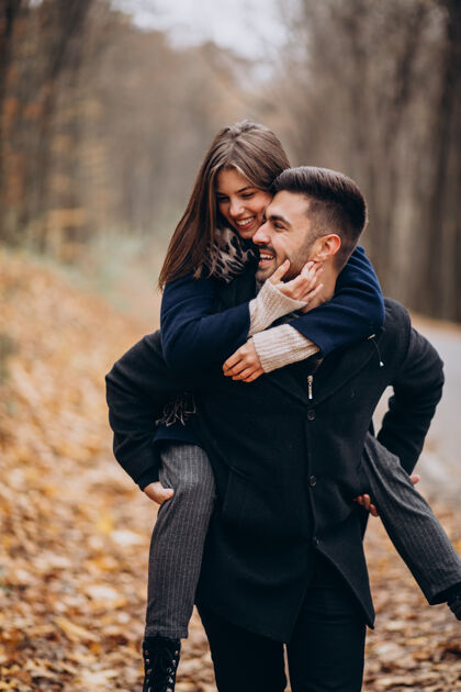 调情一对年轻夫妇在秋天的公园里散步快乐森林男人