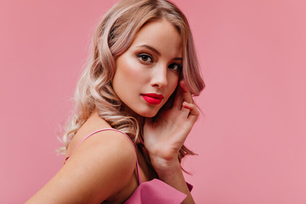 瘦身年轻浪漫可爱的金发女郎 模特模样 浓妆艳抹 在粉红色的隔离墙上摆出肖像派对室内服装