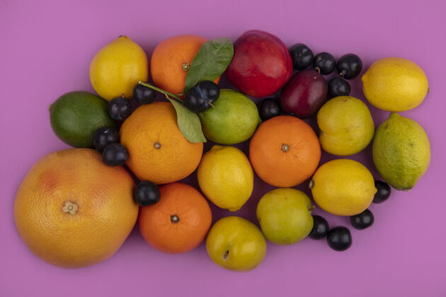 粉红色顶视图水果混合葡萄柚 橘子 柠檬 酸橙 李子 樱桃 李子和桃子 粉色背景柠檬混合葡萄柚
