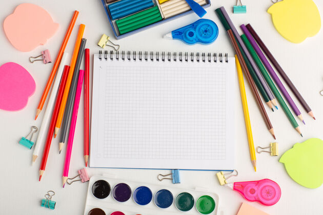 教育顶视图彩色铅笔与油漆记事本和贴纸上的白色书桌艺术画彩色油漆绘画彩虹顶部