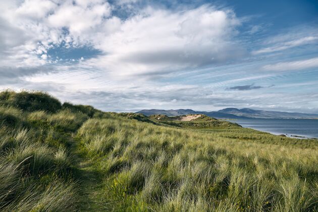 运动爱尔兰被罗斯贝海滩和大海包围的草地覆盖的丘陵景观山海洋大西洋