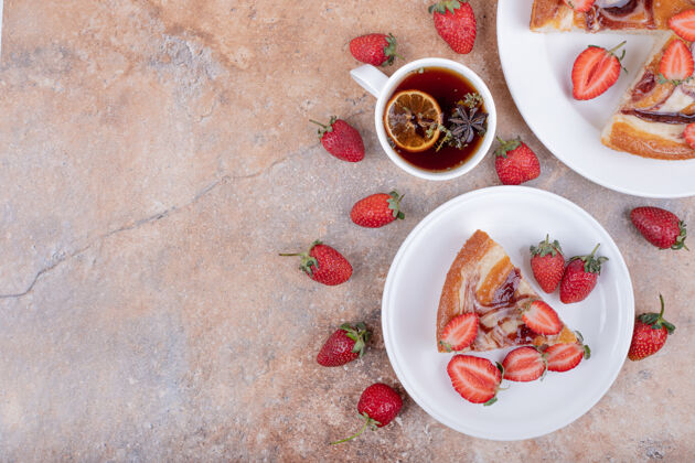 陶瓷一杯茶 在白色盘子里放一个草莓甜馅饼奶油精致地壳