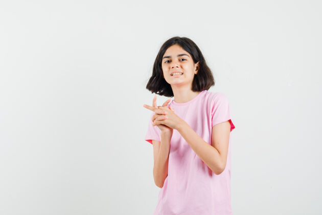 青少年小女孩保持双手和手指紧握在粉红色t恤正面视图肖像手指保持