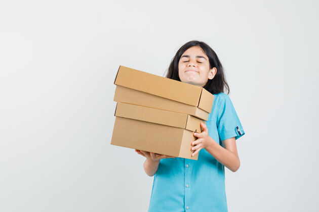 休闲穿蓝衬衫的年轻女士提着沉重的箱子 看上去很复杂沉重时尚盒子