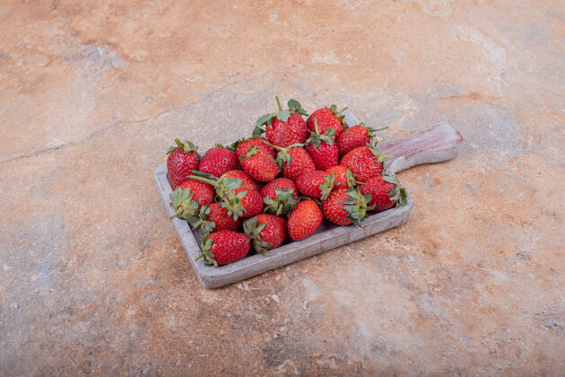 美味红色草莓放在大理石上的乡村木盘里素食新鲜清淡