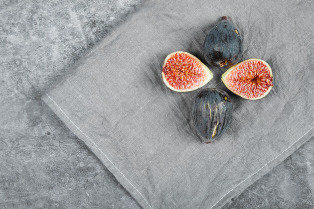 收获用灰色桌布把成熟的无花果放在大理石表面有机水果种子