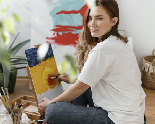 创意在家里用丙烯酸树脂绘画的年轻女子放松艺术油漆