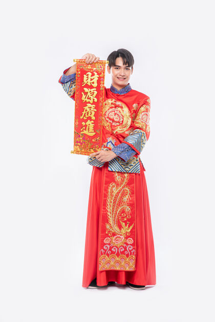 男人穿旗袍西服 穿黑鞋的男人在中国新年给家人送上中国贺卡祝好运男孩文化成人