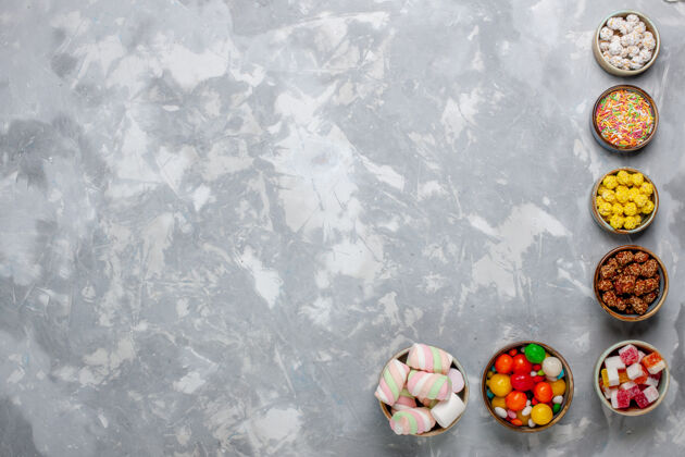 昆虫顶视图糖果组成不同颜色的糖果与棉花糖内罐在白色的办公桌上糖果邦邦甜封颜色瓢虫桌子