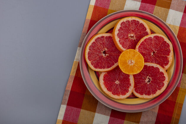 格子俯视图柚子片在一个灰色背景的格子多色彩毛巾板上毛巾五彩灰色