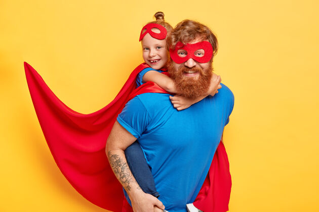 为人父母开朗体贴的爸爸带着小女儿玩给英雄的孩子背上游戏超级英雄小