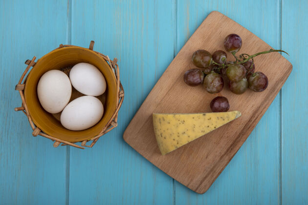 风景顶视图奶酪与葡萄板和鸡蛋在一个蓝绿色的背景篮子金色顶部食物