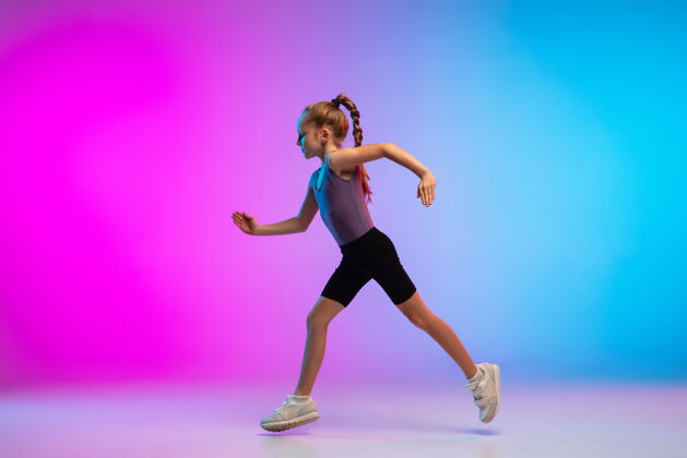 运动员健康少女 专业跑步者 慢跑者 在霓虹灯下的渐变粉蓝色背景上运动隔离运动 运动 活力和动态的概念 健康的生活方式运动员儿童肌肉