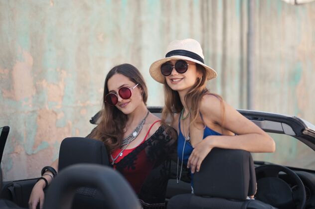 眼镜两位女性朋友在敞篷跑车上配饰的美丽照片友谊太阳镜社交