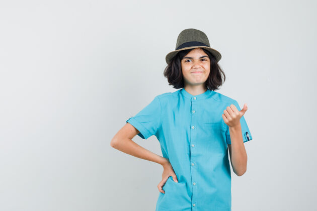 帽子穿蓝色t恤的小女孩 戴着一顶大拇指朝上的帽子 看上去很高兴休闲可爱年轻