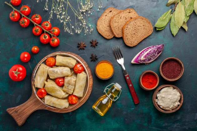 卡路里俯瞰美味的肉食卷心菜内卷油面包和新鲜西红柿在深蓝色桌肉食品晚餐热量蔬菜菜烹饪新鲜生的菜肴