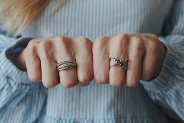 奢侈品特写镜头一位女性戴着漂亮的戒指在双手和显示与拳头手指闪亮钻石
