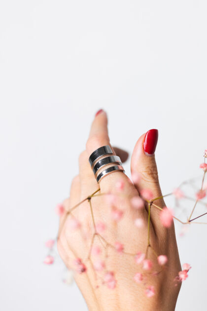 花柔美温柔的照片 女人手上戴着大戒指 红色的指甲 手上拿着可爱的粉色干花浪漫美丽皮肤