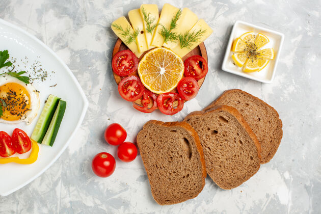 绿色顶视图板上有食物蔬菜和蔬菜 奶酪和面包放在浅白的桌子上蔬菜食物午餐早餐清淡奶酪吐司