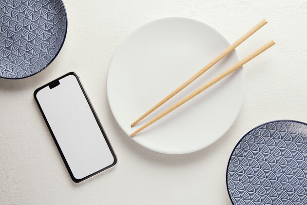 分类顶视图安排优雅的餐具与智能手机桌子空的陶器