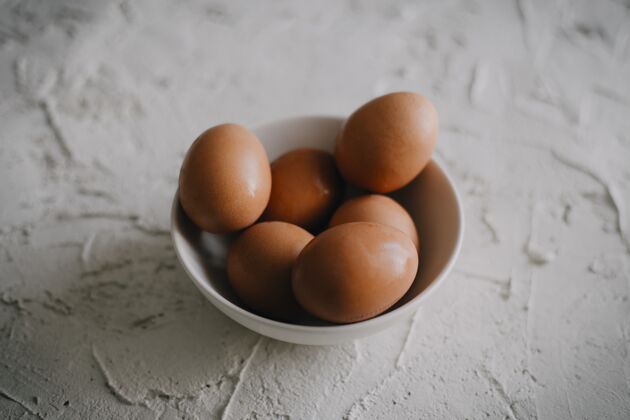 餐白色表面上一碗鸡蛋的高角度拍摄鸡蛋生的营养