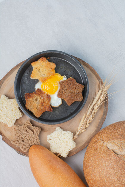 鸡蛋白面包片和棕色面包片 木盘上有煎蛋盘子食物切片