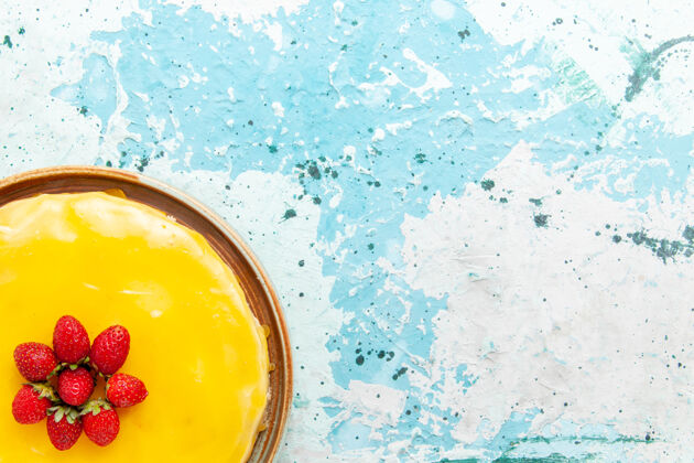 糖浆俯瞰美味的蛋糕 黄色糖浆和红色草莓放在蓝色桌子上饼干蛋糕甜饼糖茶透明蛋糕茶