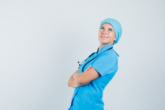 年轻人身穿蓝色制服的女医生交叉着双臂站着 神情沉思疾病制服实验室