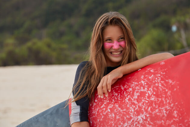 快乐表情愉快的欧洲美女照片 为冲浪欢天喜地 手持打蜡冲浪板 喜欢水上运动 穿着潜水服 想展示下转身横拍沙滩海洋青少年