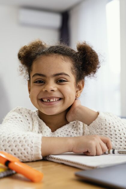 虚拟前视图的快乐小女孩在家里 在网上学校与笔记本电脑知识学习小