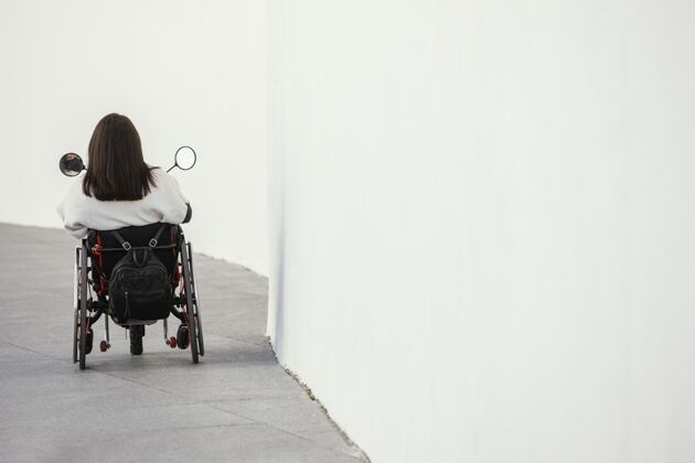 紊乱坐在轮椅上的女士的后视图 有复印空间户外残障户外