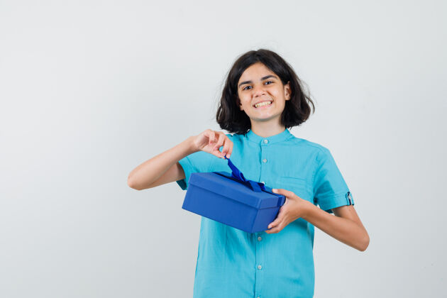 时尚年轻女孩拿着礼物盒 穿着蓝色衬衫微笑着 看起来很开心举行青少年青年
