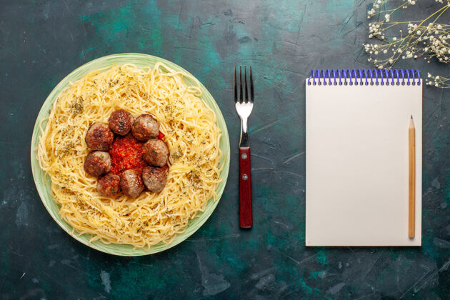 意大利面俯瞰美味的意大利面食 在深蓝色面团上放肉丸子和番茄酱面食晚餐景观顶部小吃