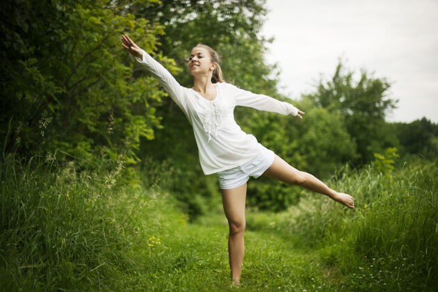 放松在大自然中练习瑜伽的女人健康的生活方式春天和谐