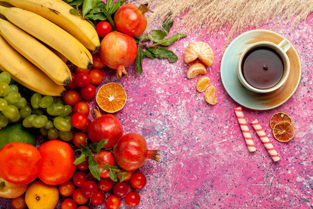 醇香前视图新鲜水果组成 浅粉色表面上有一杯茶饮食杯子维生素