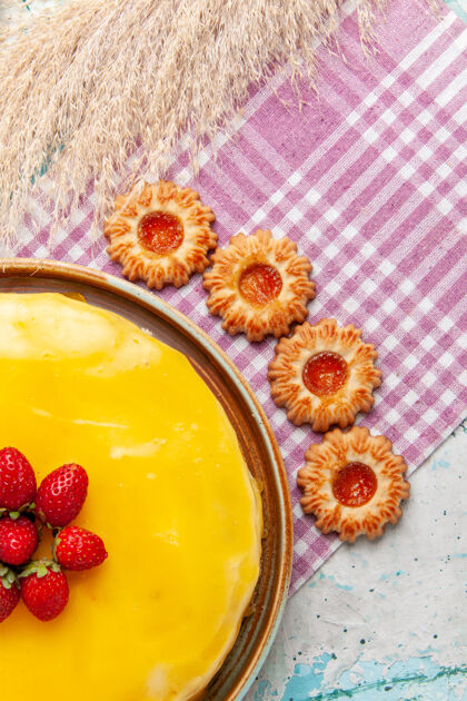 甜点俯瞰美味的黄色糖浆蛋糕新鲜的红色草莓和饼干在蓝色桌子饼干蛋糕烤甜甜的糖派茶蛋糕浆果草莓