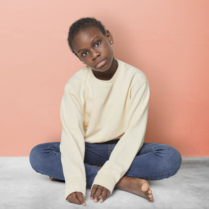 黑人儿童穿米色毛衣的黑小子地板正方形简约