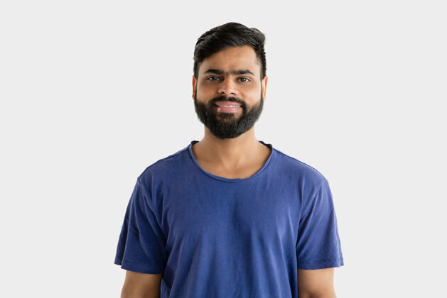 印度语美丽的男性半身肖像隔离在白色的工作室背景年轻情绪化的印度教男子在蓝色衬衫面部表情 人类情感 广告概念站立和微笑表情站立印度教