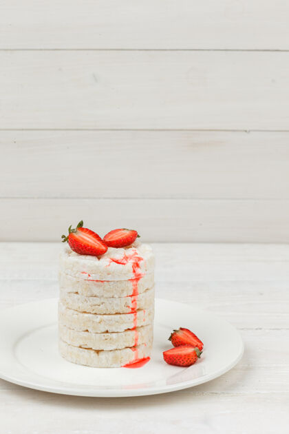 美味高角度观看白米饼与草莓在白色木板表面板垂直自由空间为您的文字新鲜草莓饼干
