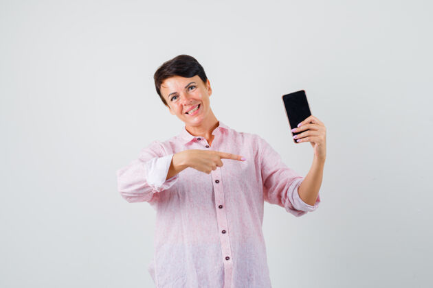电话穿着粉色衬衫的女性指着手机 看上去很欢快 正面照肖像手机女人