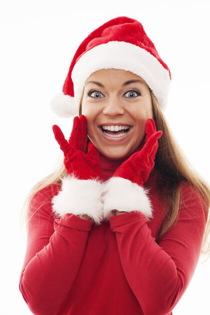 圣诞节戴着圣诞帽和手套的年轻女人看起来很兴奋毛皮惊喜快乐