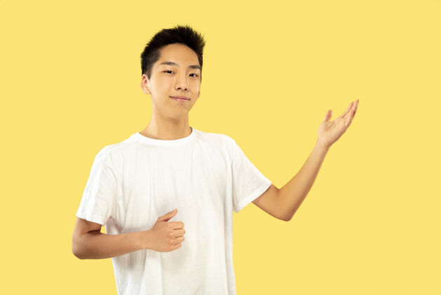 商人黄色工作室背景上的韩国年轻人半身像穿白衬衫的男模展示一些东西人类情感的概念 面部表情正面视图流行的颜色手韩国人手势