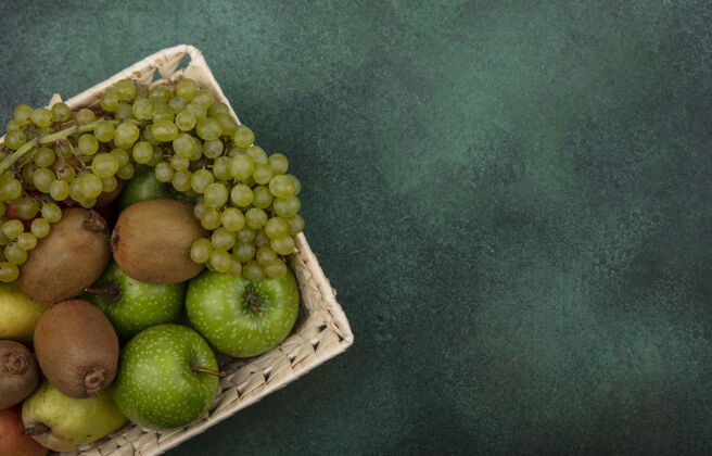 新鲜顶视图复制空间与绿色背景上的绿色苹果 葡萄和梨篮子猕猴桃多汁葡萄苹果