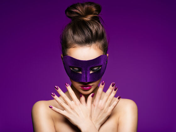 女性一个漂亮女人的肖像 紫色的指甲 脸上戴着紫色的戏剧面具魅力指甲迷人